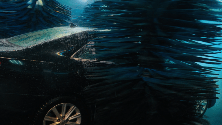 car using a touchless car wash tunnel at Red Carpet Car Wash